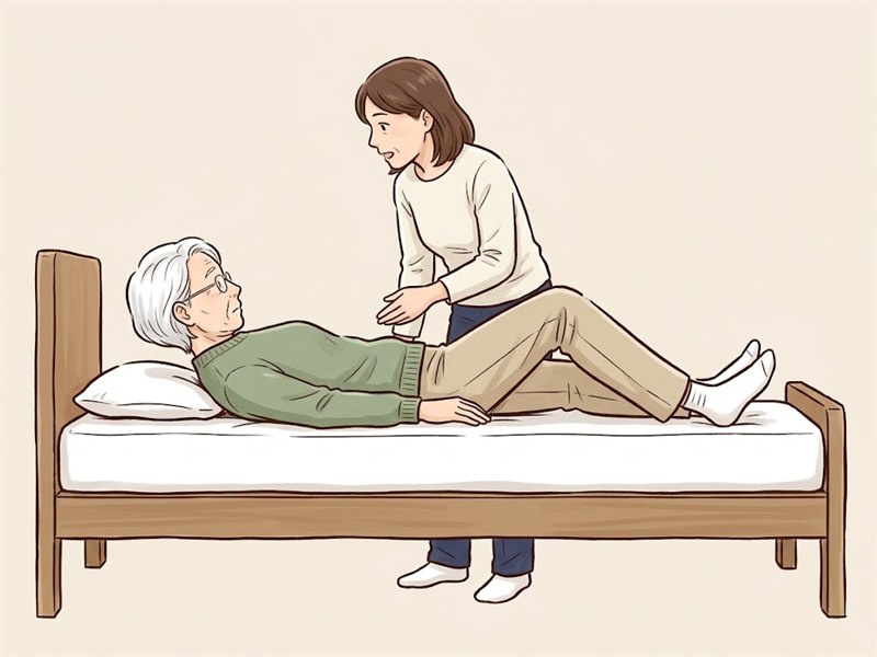 あおむけの方があごを引いて自分のおへそのほうを見ている。そばに立つ介助者がおなかのあたりを手で示している