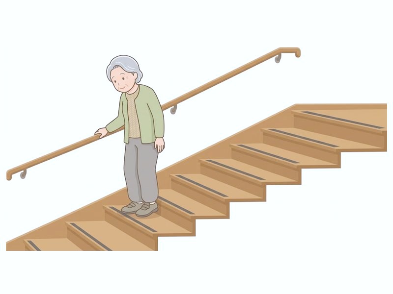 手すりにつかまって階段を下りる図